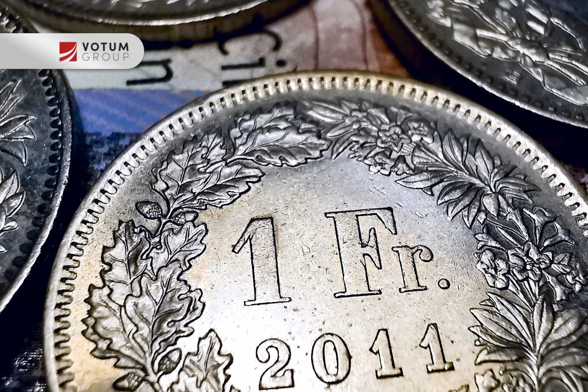 czy-pozew-frankowy-wplywa-na-bik Zdjęcie monety 1 frank szwajcarski z 2011 roku otoczonej liśćmi i kwiatami – symbolizujące kredyty frankowe.