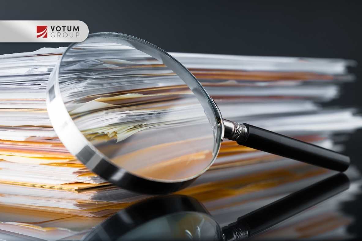 Stos dokumentów oglądany przez lupę – analiza sprawy frankowej przez ekspertów Votum Group.