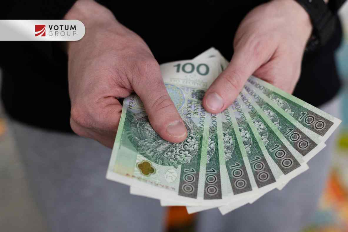 Zbliżenie na dłonie trzymające wachlarz banknotów studolarowych (PLN 100)