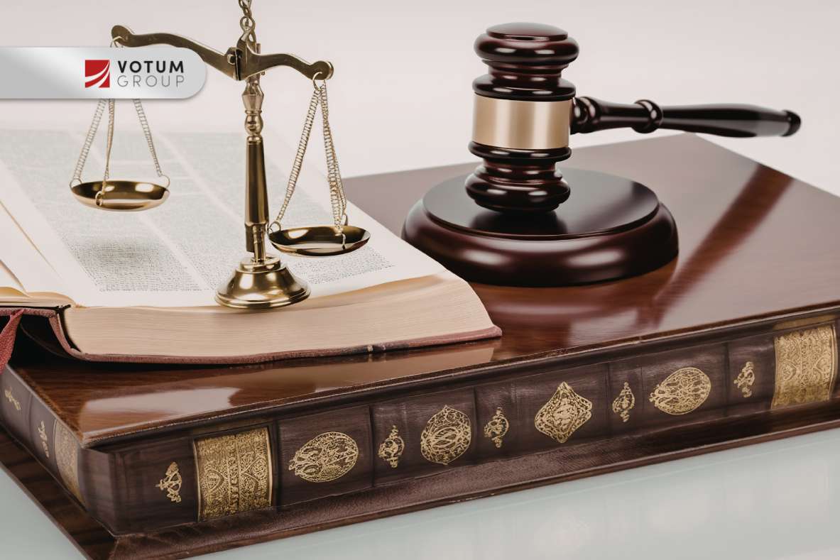 Legal scene with scales of justice, a gavel, and an open law book, featuring the VOTUM GROUP logo in the corner