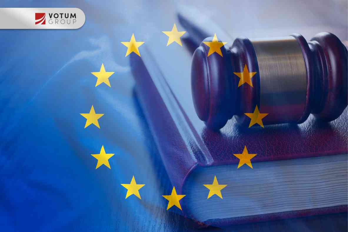 Widok z dołu na ciemny posąg Temidy trzymającej wzniesiony, lśniący miecz oraz wagę szali na tle czystego, błękitnego nieba.