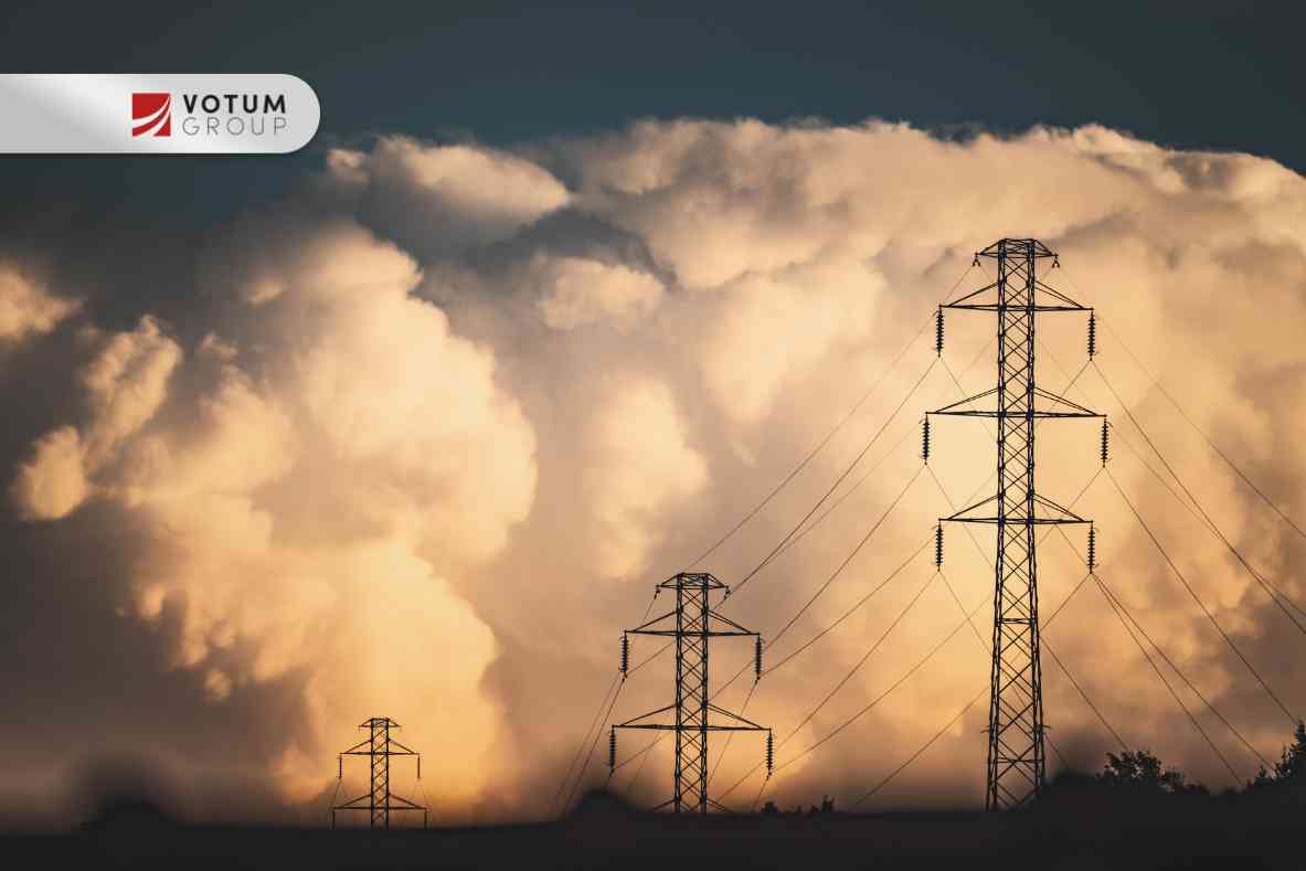 Wysokie słupy i linie energetyczne na tle burzowych chmur ograniczające korzystanie z działki.